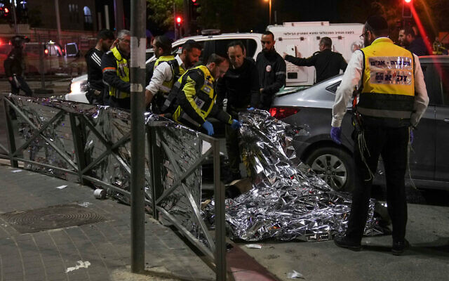 Members of Zaka Rescue and Recovery team check a body after the terror shooting attack in Jerusalem, Jan. 27, 2023 Photo: AP Photo/Mahmoud Illean Members of Zaka Rescue and Recovery team check a body after the terror shooting attack in Jerusalem, Jan. 27, 2023 Photo: AP Photo/Mahmoud Illean