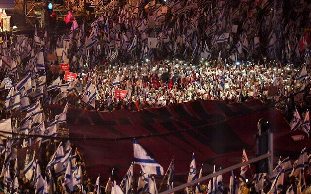 Demonstrators lift national flags during a protest against the Israeli government's controversial judicial reform bill in Tel Aviv on March 11, 2023. (Photo by JACK GUEZ / AFP) Demonstrators lift national flags during a protest against the Israeli government's controversial judicial reform bill in Tel Aviv on March 11, 2023. (Photo by JACK GUEZ / AFP)