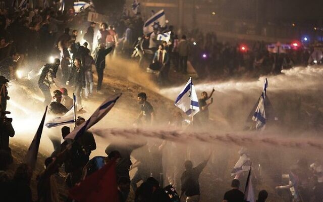 Israeli police use a water cannon to disperse demonstrators blocking a highway during a protest in Tel Aviv.
Photo: AP/Oren Ziv Israeli police use a water cannon to disperse demonstrators blocking a highway during a protest in Tel Aviv.
Photo: AP/Oren Ziv