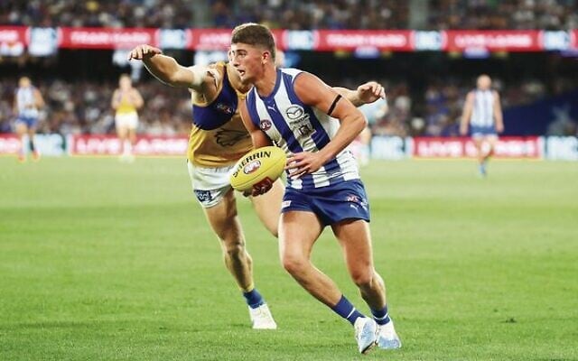AFL debutant Harry Sheezel looks to offload a handball before being swallowed up in a tackle during the opening round of the season at Marvel Stadium. Photo: Peter Haskin AFL debutant Harry Sheezel looks to offload a handball before being swallowed up in a tackle during the opening round of the season at Marvel Stadium. Photo: Peter Haskin