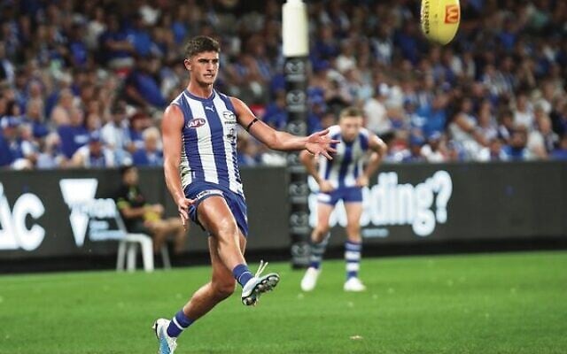Harry Sheezel kicks to a Kangaroos teammate during his AFL match debut. Harry Sheezel kicks to a Kangaroos teammate during his AFL match debut.
