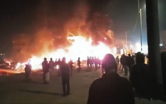 Settlers pray the evening service, as cars and homes they torched burn in the West Bank town of Huwara on February 26.
Photo: Twitter screenshot Settlers pray the evening service, as cars and homes they torched burn in the West Bank town of Huwara on February 26.
Photo: Twitter screenshot