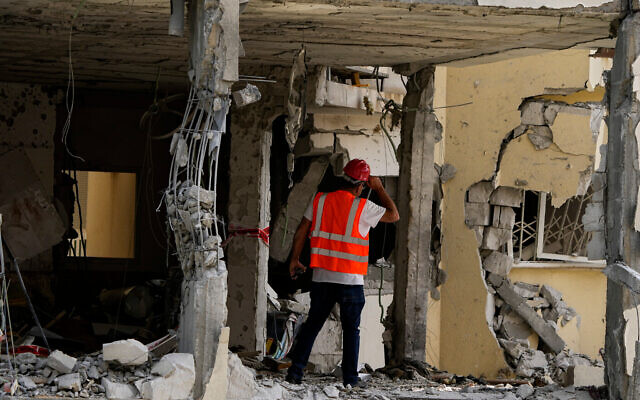 A municipality worker inspects the damage to an apartment building a day after it was hit by a rocket fired from the Gaza Strip, in Rehovot, Israel, Friday, May 12, 2023. Photo: AP/Ariel Schalit A municipality worker inspects the damage to an apartment building a day after it was hit by a rocket fired from the Gaza Strip, in Rehovot, Israel, Friday, May 12, 2023. Photo: AP/Ariel Schalit