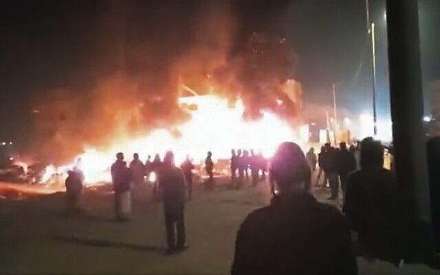 Settlers pray as cars and homes burn in Huwara on February 26.
Photo: Screenshot/Twitter Settlers pray as cars and homes burn in Huwara on February 26.
Photo: Screenshot/Twitter