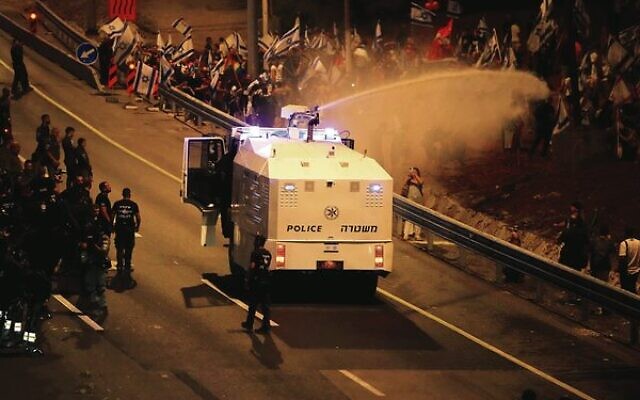 Police use a water cannon to disperse demonstrators in Tel Aviv on July 18.
Photo: Ariel Schalit/AP Police use a water cannon to disperse demonstrators in Tel Aviv on July 18.
Photo: Ariel Schalit/AP