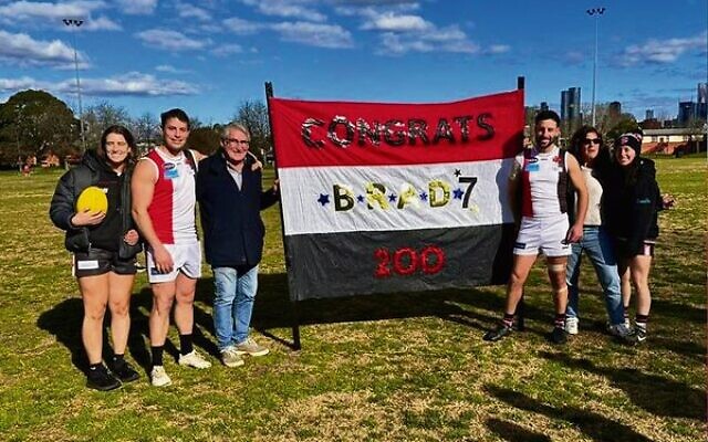 Brad Caplan (third from right) next to his 200th game banner. Brad Caplan (third from right) next to his 200th game banner.
