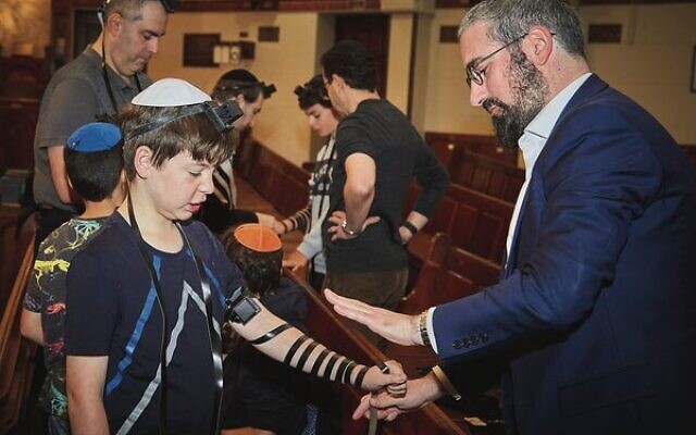 Louis Super (left) lays Tefillin with Rabbi Yaakov Glasman. Photo: Paul Topol. Louis Super (left) lays Tefillin with Rabbi Yaakov Glasman. Photo: Paul Topol.