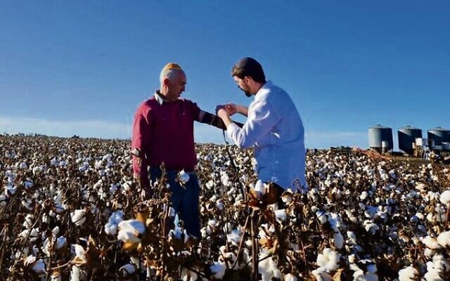 Rabbi Yaakov Zarchi putting tefillin on Howard Rother in his cotton fields in Queensland's Darling Downs last week. Rabbi Yaakov Zarchi putting tefillin on Howard Rother in his cotton fields in Queensland's Darling Downs last week.
