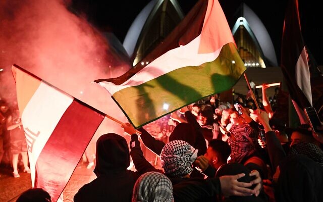 Participants of a Free Palestine rally react as flares are lit outside the Sydney Opera House in Sydney, Monday, October 9, 2023. Israel has pounded the Palestinian enclave of Gaza, killing hundreds of people in retaliation for one of the bloodiest attacks in its history when Islamist group Hamas killed 700 Israelis and abducted dozens more. (AAP Image/Dean Lewins) NO ARCHIVING Participants of a Free Palestine rally react as flares are lit outside the Sydney Opera House in Sydney, Monday, October 9, 2023. Israel has pounded the Palestinian enclave of Gaza, killing hundreds of people in retaliation for one of the bloodiest attacks in its history when Islamist group Hamas killed 700 Israelis and abducted dozens more. (AAP Image/Dean Lewins) NO ARCHIVING