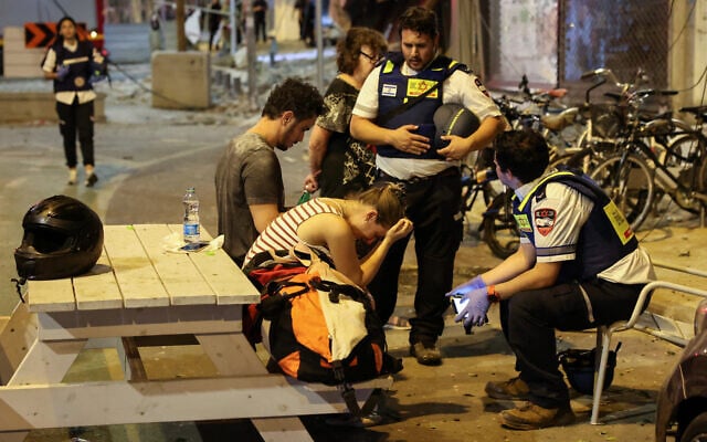 A young woman reacts as she speaks to Israeli rescuers in Tel Aviv, after a rocket strike from the Gaza Strip on October 7, 2023. (JACK GUEZ / AFP) A young woman reacts as she speaks to Israeli rescuers in Tel Aviv, after a rocket strike from the Gaza Strip on October 7, 2023. (JACK GUEZ / AFP)