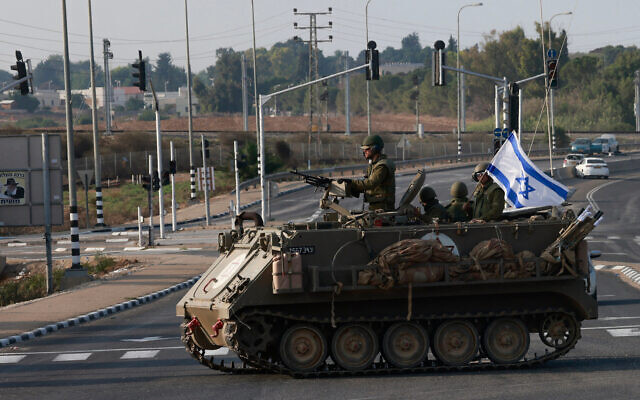 Israeli forces cross a main road in an armored personnel carrier (APC) as additional IDF troops are deployed near the southern city of Sderot following an assault by Hamas terrorists, October 8, 2023. (Menahem KAHANA/AFP) Israeli forces cross a main road in an armored personnel carrier (APC) as additional IDF troops are deployed near the southern city of Sderot following an assault by Hamas terrorists, October 8, 2023. (Menahem KAHANA/AFP)