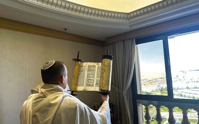A member of Communications Minister Shlomo Karhi's delegation holds up a Torah scroll during a morning prayer service in Riyadh, Saudi Arabia. Photo: Communications Ministry A member of Communications Minister Shlomo Karhi's delegation holds up a Torah scroll during a morning prayer service in Riyadh, Saudi Arabia. Photo: Communications Ministry