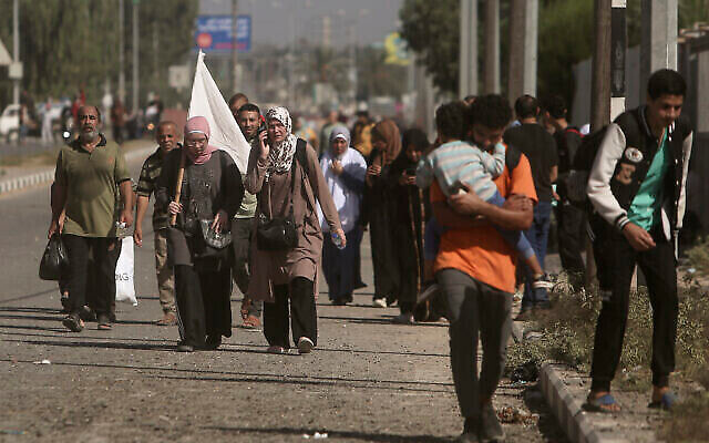 A woman carries a white flag with a group of Palestinians fleeing Gaza City to the southern Gaza Strip on Salah al-Din street in Bureij, November 7, 2023. (The Times of Israel: AP Photo/Mohammed Dahman) A woman carries a white flag with a group of Palestinians fleeing Gaza City to the southern Gaza Strip on Salah al-Din street in Bureij, November 7, 2023. (The Times of Israel: AP Photo/Mohammed Dahman)