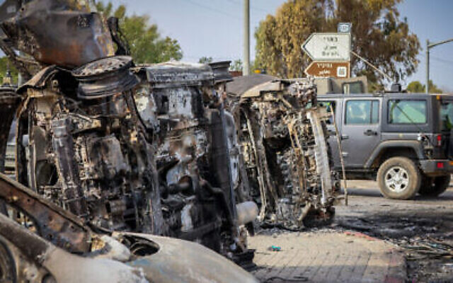 Israeli security seen next to burnt cars at the entrance to Kibbutz Be’eri, near the Israeli-Gaza Border, in southern Israel, Oct. 9, 2023. (AJNUK: Yossi Zamir/Flash90) רחבות ברזל Israeli security seen next to burnt cars at the entrance to Kibbutz Be’eri, near the Israeli-Gaza Border, in southern Israel, Oct. 9, 2023. (AJNUK: Yossi Zamir/Flash90) רחבות ברזל