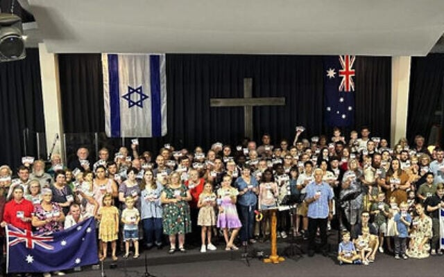 The Manning Valley Covenant Ministries congregation holding an Israeli flag and small posters of Israeli hostages, in early December. The Manning Valley Covenant Ministries congregation holding an Israeli flag and small posters of Israeli hostages, in early December.