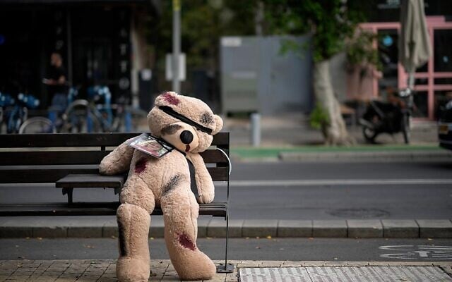 A giant teddy bear dedicated to Emilia Aloni, aged five, with its eyes covered and showing signs of injury sits on a street bench in Tel Aviv to draw attention to the plight of the hostages. Aloni and her mother were released by Hamas, but many of their relatives remain in Gaza. (Keller: via Christopher Furlong/Getty Images) A giant teddy bear dedicated to Emilia Aloni, aged five, with its eyes covered and showing signs of injury sits on a street bench in Tel Aviv to draw attention to the plight of the hostages. Aloni and her mother were released by Hamas, but many of their relatives remain in Gaza. (Keller: via Christopher Furlong/Getty Images)