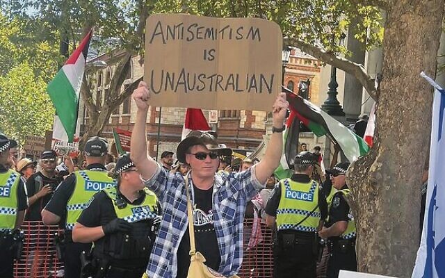 A man holds a sign against antisemitism while anti-Israel protesters congregate in the background. Photo: Lisa Goldberg A man holds a sign against antisemitism while anti-Israel protesters congregate in the background. Photo: Lisa Goldberg