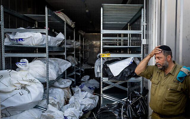 A military official at the forensic center at the Military Rabbinate's headquarters in Ramle stands in front of the remains of victims of Hamas's October 7 onslaught in Israel, October 13, 2023. (The Times of Israel: Nati Shohat/Flash90) A military official at the forensic center at the Military Rabbinate's headquarters in Ramle stands in front of the remains of victims of Hamas's October 7 onslaught in Israel, October 13, 2023. (The Times of Israel: Nati Shohat/Flash90)