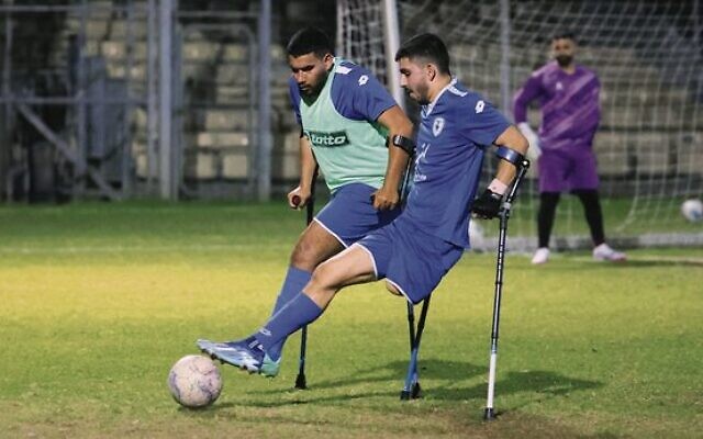 The team's striker, Ben Maman (right), challenges for the ball at training in Ramat Gan on March 28. Photo: Jack Guez/AFP The team's striker, Ben Maman (right), challenges for the ball at training in Ramat Gan on March 28. Photo: Jack Guez/AFP