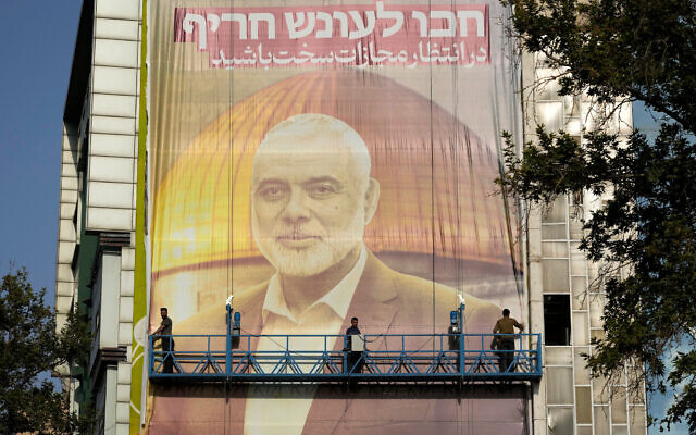 Iranian workers install a huge banner on a wall showing a portrait of Hamas terror group leader Ismail Haniyeh and the Dome of Rock Islamic shrine atop the Temple Mount in Jerusalem with a sign which reads in Farsi and Hebrew: "Expect severe punishment," at Palestine Square in Tehran, Iran, July 31, 2024. Haniyeh was assassinated in the city hours earlier. (AP Photo/Vahid Salemi) Iranian workers install a huge banner on a wall showing a portrait of Hamas terror group leader Ismail Haniyeh and the Dome of Rock Islamic shrine atop the Temple Mount in Jerusalem with a sign which reads in Farsi and Hebrew: "Expect severe punishment," at Palestine Square in Tehran, Iran, July 31, 2024. Haniyeh was assassinated in the city hours earlier. (AP Photo/Vahid Salemi)