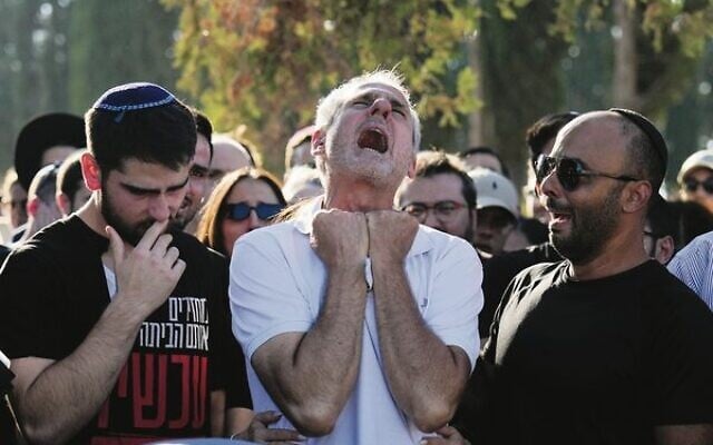 Yigal Sarusi (centre) mourns during the funeral of his son, slain hostage Almog Sarusi. Photo: AP Photo/Ariel Schalit Yigal Sarusi (centre) mourns during the funeral of his son, slain hostage Almog Sarusi. Photo: AP Photo/Ariel Schalit