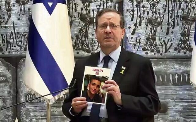 Israel's president Isaac Herzog during the webinar, holding a poster of hostage Edan Alexander. Photo: Screenshot Israel's president Isaac Herzog during the webinar, holding a poster of hostage Edan Alexander. Photo: Screenshot