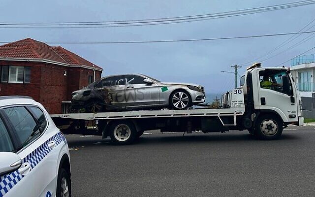 A burnt car with antisemitic graffiti is towed away in Dover Heights on January 17. Photo: AAP Image/Neve Brissendeni A burnt car with antisemitic graffiti is towed away in Dover Heights on January 17. Photo: AAP Image/Neve Brissendeni