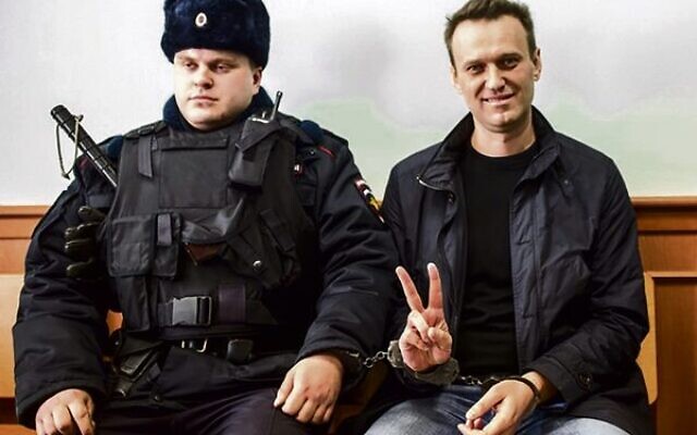 Alexei Navalny, handcuffed to a policeman, gestures to the press in Moscow, 2017. Photo: Evgeny Feldman. Alexei Navalny, handcuffed to a policeman, gestures to the press in Moscow, 2017. Photo: Evgeny Feldman.