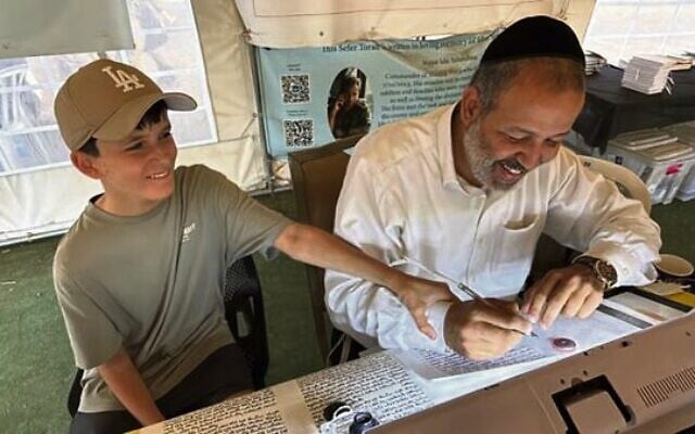 Teri Lichtenstein's son receiving a letter in his name in a new Sefer Torah written in honour of a victim at the Nova festival site. Teri Lichtenstein's son receiving a letter in his name in a new Sefer Torah written in honour of a victim at the Nova festival site.