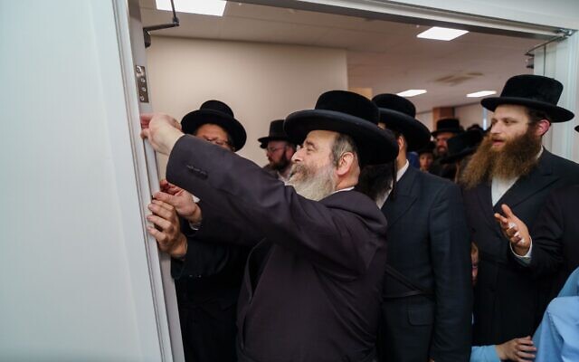 Chief Rabbi of Adass Israel, Shlome Kohn, affixing the mezuzah at the new temporary premises. Photo: Adass Israel. Chief Rabbi of Adass Israel, Shlome Kohn, affixing the mezuzah at the new temporary premises. Photo: Adass Israel.