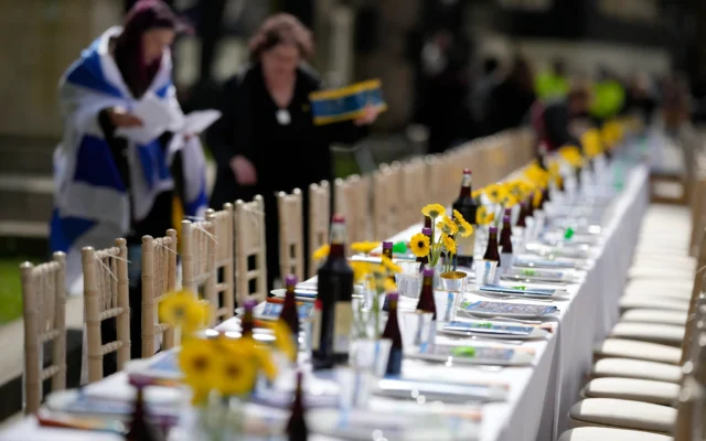 Illustrative: Two women, one of them wrapped in an Israeli flag, help to set the 'The Empty Seder Table,’ with 133 chairs and place settings, representing hostages still being held in Gaza by Hamas, in front of Downing Street in London, Britain, April 17, 2024. (AP Photo/Alastair Grant) Illustrative: Two women, one of them wrapped in an Israeli flag, help to set the 'The Empty Seder Table,’ with 133 chairs and place settings, representing hostages still being held in Gaza by Hamas, in front of Downing Street in London, Britain, April 17, 2024. (AP Photo/Alastair Grant)