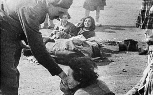 A woman inmate of Belsen concentration camp kisses the hand of Army Film & Photographic Unit cameraman Lieutenant Martyn Wilson on liberation. Photo: Mike Lewis A woman inmate of Belsen concentration camp kisses the hand of Army Film & Photographic Unit cameraman Lieutenant Martyn Wilson on liberation. Photo: Mike Lewis