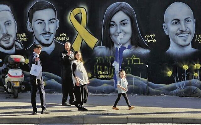 Passersby in front of a mural depicting Israeli hostages in Jerusalem. Photo: Alan Meerkin Passersby in front of a mural depicting Israeli hostages in Jerusalem. Photo: Alan Meerkin