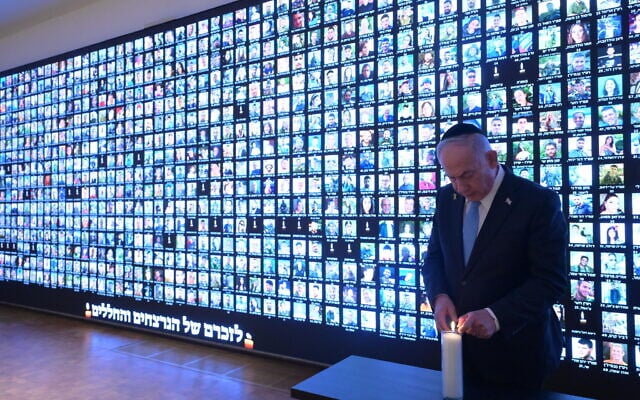 Prime Minister Benjamin Netanyahu lights a candle in memory of the victims of the war against Hamas in Gaza, next to a wall with faces of victims, at the National Library of Israel in Jerusalem, October 12, 2025. (Amos Ben Gershom/GPO) Prime Minister Benjamin Netanyahu lights a candle in memory of the victims of the war against Hamas in Gaza, next to a wall with faces of victims, at the National Library of Israel in Jerusalem, October 12, 2025. (Amos Ben Gershom/GPO)