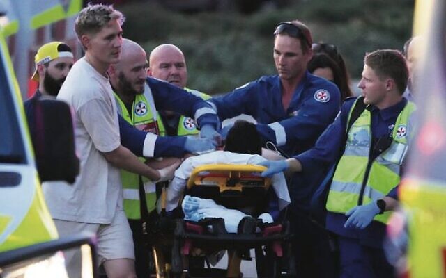 A person is aided by paramedics after the shooting at a Chanukah event at Bondi Beach. Photo: AP Photo/Mark Baker A person is aided by paramedics after the shooting at a Chanukah event at Bondi Beach. Photo: AP Photo/Mark Baker