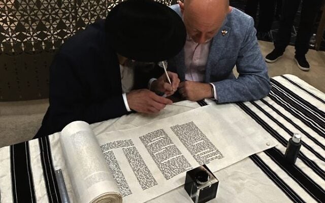 Arsen Ostrovsky (right) prepares to write letters in the Torah. Photo: Facebook Arsen Ostrovsky (right) prepares to write letters in the Torah. Photo: Facebook