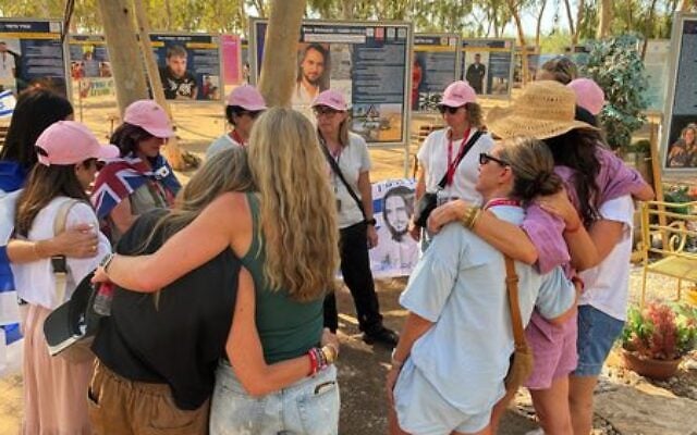 The ORAH Sydney group comfort each other after scattering sand from Bondi at the Nova Music Festival site. Photo: supplied The ORAH Sydney group comfort each other after scattering sand from Bondi at the Nova Music Festival site. Photo: supplied