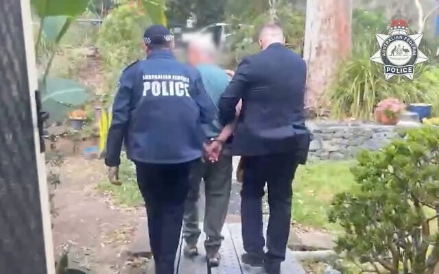 The man is led away by AFP officers. Photo: Australian Federal Police The man is led away by AFP officers. Photo: Australian Federal Police