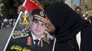 سيدة مصرية تقبل صورة السيسي في ميدان التحرير 6 اوكتوبر 2013 (أرشيف خالد دسوقي أ ف ب)