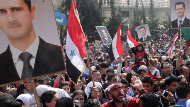 دمشق سوريا, سوريون يرفعون العلم السوري وصور بشار الاسد في مظاهرة لتأييد النظام في حي دومار (أ ف ب)