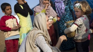 انجلينا جولي تتحدث الى طفلة لاجئة سورية في مخيم لاجئين بقرب زحلة في لبنان 24 فبراير 2014 (UNHCR/AFP)