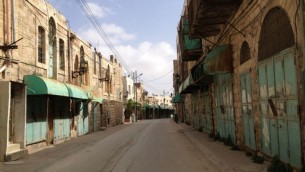 شارع الشهداء كان في الماضي سوقا حافلا اما اليوم فهو مغلق بوجوه المشاه الفلسطينين مما يجهله مهجورا معظم النهار (بعدسة الحانان ميلر / طاقم تايمز اوف اسرائيل)