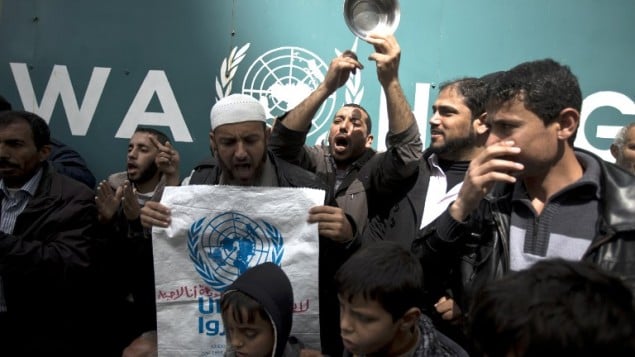 فلسطينيون خلال مظاهرة ضد قرار اونروا بتقليص المساعدات الغذائية امام مقر اونروا في غزة 16 مارس 2014 (بعدسة محمد عبد/ أ ف ب)