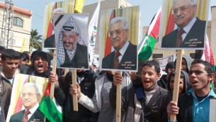 متظاهرون فلسطينيون يحملون صور الرئيس محمود عباس والرئيس الراحل ياسر عرفات دعما لعباس قبيل لقائه مع الرئيس الامريكي باراك أوباما في واشنطن 16 مارس 2014 (بعدسة جفار عشتيّة / أ ف ب)