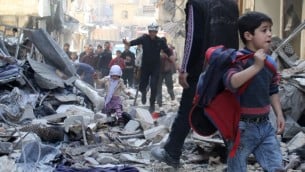 قوات الانقاذ تساعد عائلة سورية في حلب بعد سقوط صاروخ موجه اتجاه قوات موالية للنظام ٢٣ مارس ٢٠١٤ (بعدسة براء الحلبي/ أ ف ب)
