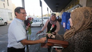 يتسحاق جليك يعرض الزهور على متشرّية فلسطينية في سوبرماركت رامي ليفي في الون شفوت ١٤ نوفمبر ٢٠١٤ (بعدسة يوسي زمير)