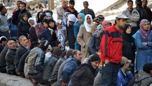 صورة مقدمة من وكالة الانباء السورية الرسمية (سانا) لسوريين في انتظار توزيع المساعدات الغذائية 31 مارس 2014  "AFP PHOTO / HO / SANA"