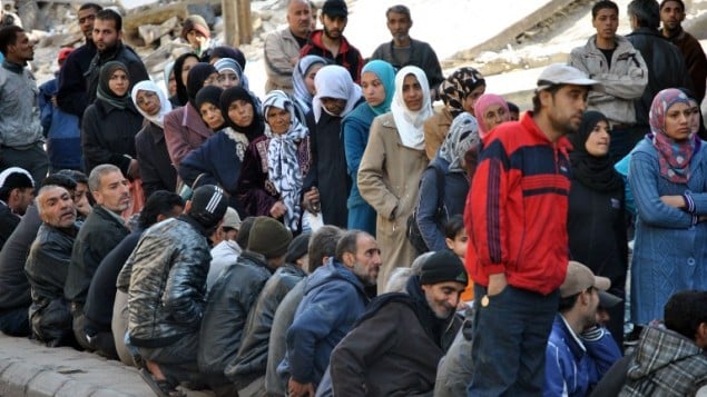 صورة مقدمة من وكالة الانباء السورية الرسمية (سانا) لسوريين في انتظار توزيع المساعدات الغذائية 31 مارس 2014  "AFP PHOTO / HO / SANA"