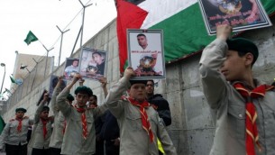 شباب فلسطيني يرفع لافتات خلال مسيرة تضامن من أجل الأسرى الفلسطينيين في السجون الإسرائيلية، التي نظمتها حماس في مخيم شعفاط للاجئين في القدس على 19 أبريل 2013 (Flash90).