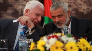 رئيس حكومة حماس إسماعيل هنية والمسؤول البارز في حركة فتح عزام الأحمد أثناء حضور مؤتمر صحفي للاعلان عن اتفاق المصالحة في غزة، 23 أبريل 2014(عبد الرحيم خطيب/ فلاش 90)